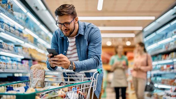 ragazzo al supermercato al telefono